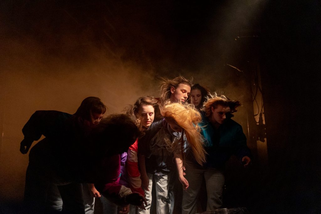 Scene from “The Year Without a Summer”: Shrouded in thick stage fog, a group of young people headbanged.