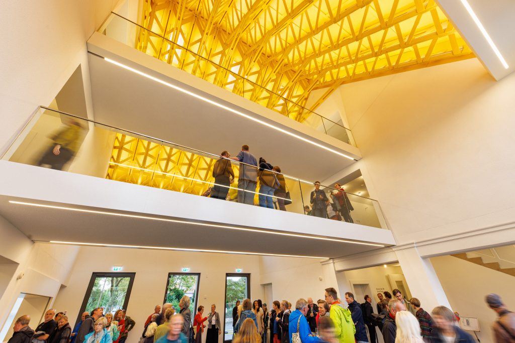 Interior view of the bright, light-filled east wing. Visitors bustle about on two of the three levels.